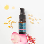 Picture of Replenishing Ritual Serum surrounded by a rose petal, frankincense resin, sunflower petals, and oil droplets