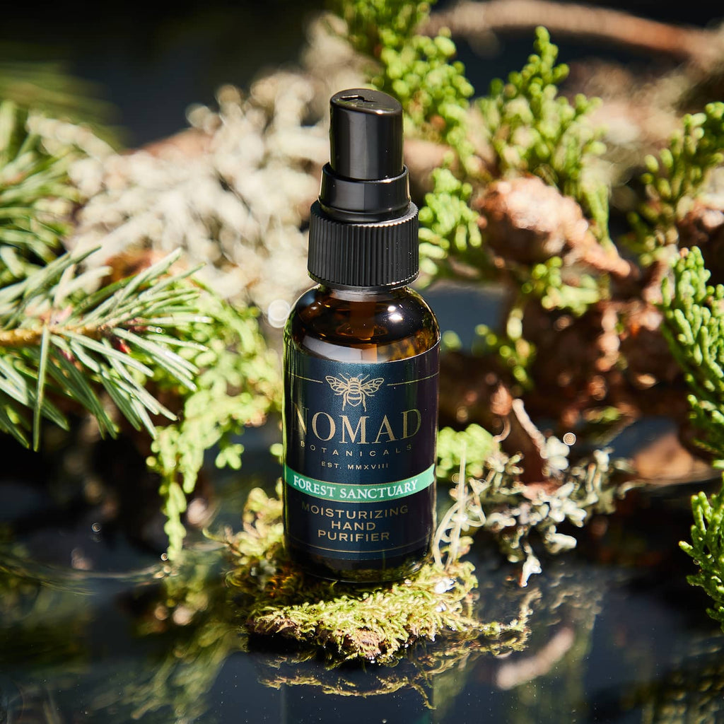 Forest Sanctuary Moisturizing Hand Purifier surrounded in by a small forest of douglas fir, scotch pine needles, and mossy elements