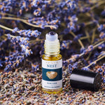 Nomad Botanicals Nest REM Gem Aromatherapy Blend surrounded with lavender stems and buds