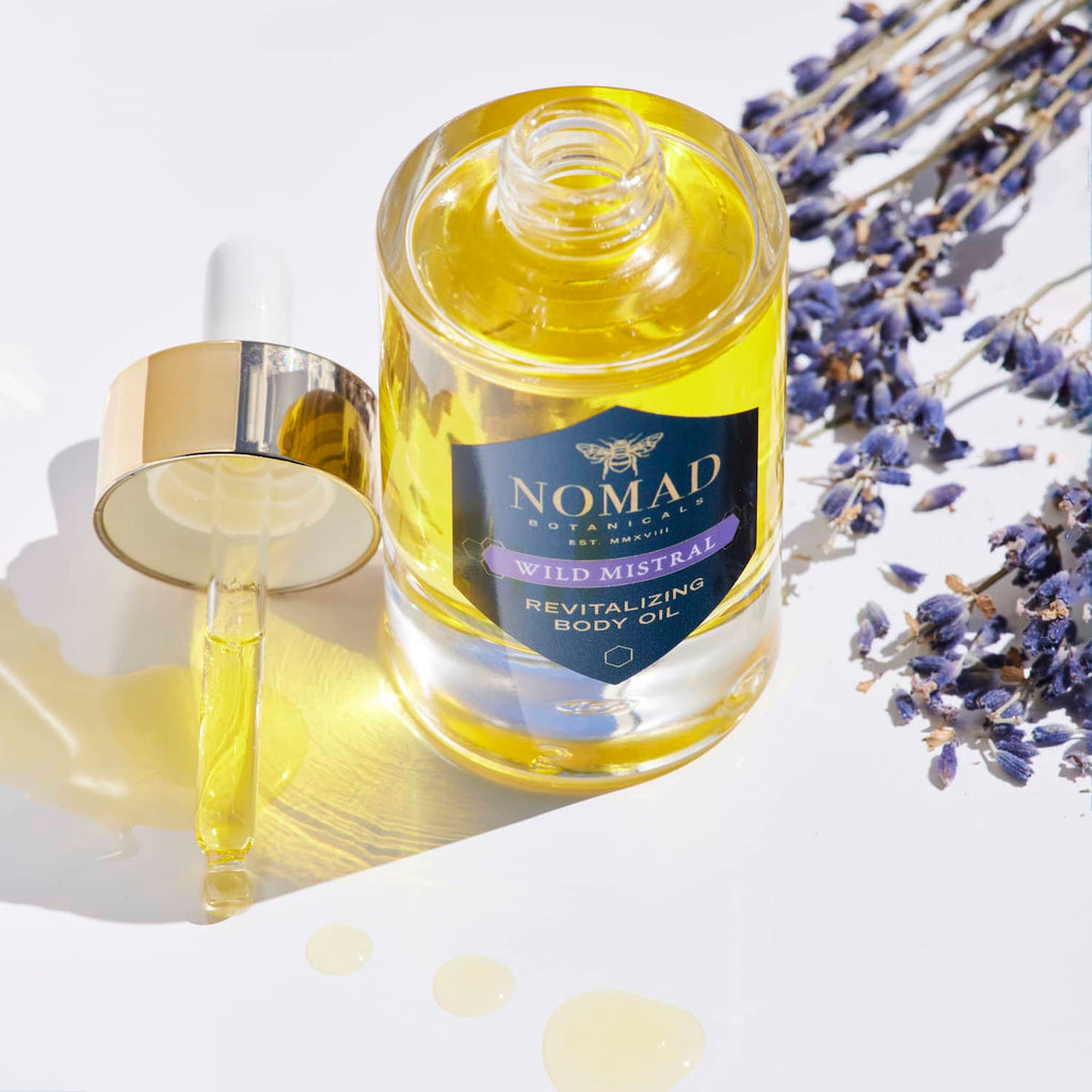 Nomad Botanicals Wild Mistral Revitalizing Body Oil flatlay surrounded by lavender